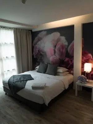 a bedroom with a bed with a painting on the wall at V Garden Hotel in Kuala Lumpur