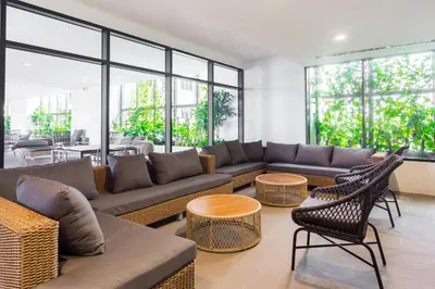 a living room with couches and tables and windows at EST Suites Bangsar by Airhost in Kuala Lumpur