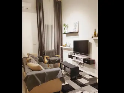 a living room with two chairs and a television at Charming Bedroom - next to train station at Est Bangsar in Kuala Lumpur