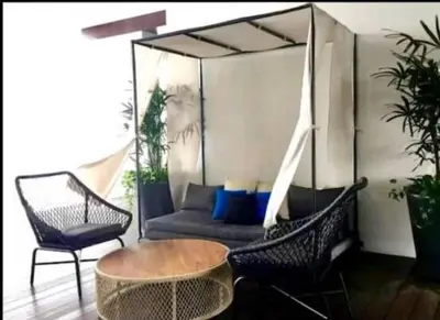 a patio with a couch and a table and chairs at Charming Bedroom - next to train station at Est Bangsar in Kuala Lumpur