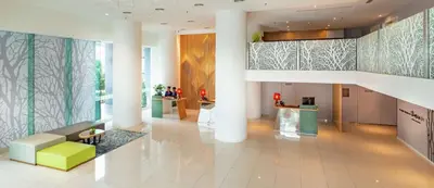 a lobby of a building with a couch and tables at Hilton Garden Inn Kuala Lumpur - South in Kuala Lumpur