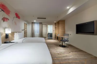 a hotel room with two beds and a flat screen tv at Hilton Garden Inn Kuala Lumpur - South in Kuala Lumpur