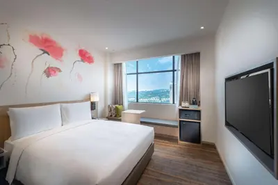 a hotel room with a bed and a flat screen tv at Hilton Garden Inn Kuala Lumpur - South in Kuala Lumpur