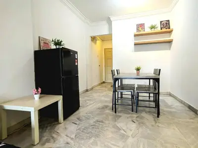 a dining room with a table and a black refrigerator at Setapak TerataiMewahApart to15min KLCC 217 in Kuala Lumpur