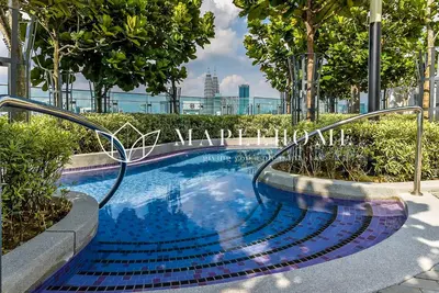 a swimming pool with stairs and trees in a city at The Robertson Kuala Lumpur in Kuala Lumpur