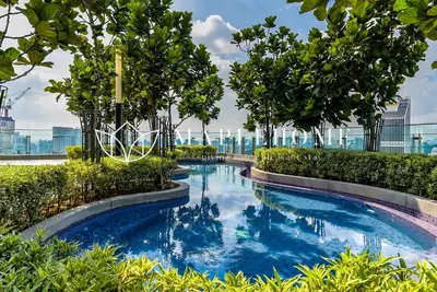 a swimming pool with blue water and trees on a building at The Robertson Kuala Lumpur in Kuala Lumpur