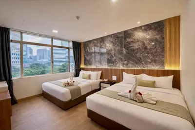 a hotel room with two beds and a large window at Swiss Hotel Kuala Lumpur in Kuala Lumpur