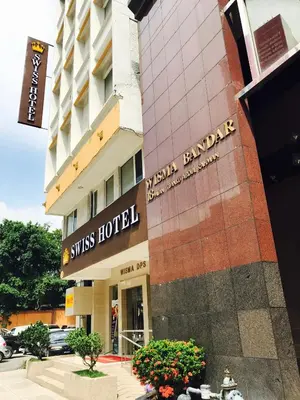 a building with a sign for a hotel at Swiss Hotel Kuala Lumpur in Kuala Lumpur