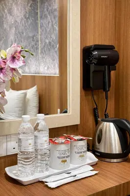 a table with two bottles of water and a phone at Swiss Hotel Kuala Lumpur in Kuala Lumpur