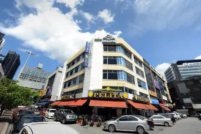 a building on a busy city street with cars parked at Palm Inn Ampang Point in Ampang