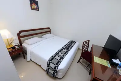a bedroom with a bed and a desk and a television at Palm Inn Ampang Point in Ampang