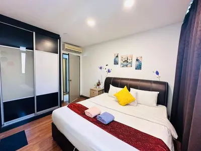 a bedroom with a large bed with yellow and blue pillows at Taragon Service Apartment- Next To LaLaport BBCC in Kuala Lumpur