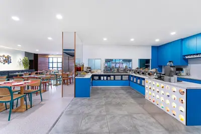 a restaurant with blue cabinets and tables and chairs at ibis Styles Kuala Lumpur Bukit Bintang in Kuala Lumpur
