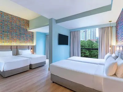 two beds in a hotel room with a window at ibis Styles Kuala Lumpur Bukit Bintang in Kuala Lumpur