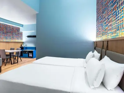 a bedroom with a white bed and a blue wall at ibis Styles Kuala Lumpur Bukit Bintang in Kuala Lumpur