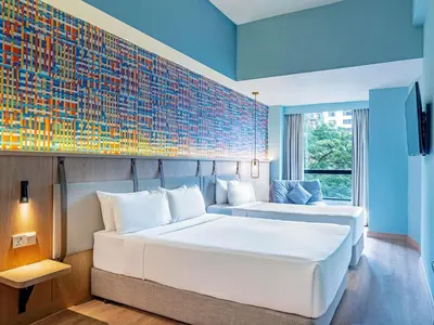 a hotel room with two beds and a wall with at ibis Styles Kuala Lumpur Bukit Bintang in Kuala Lumpur