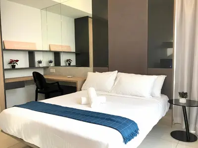 a bedroom with a white bed with a blue blanket on it at The Robertson KL in Kuala Lumpur