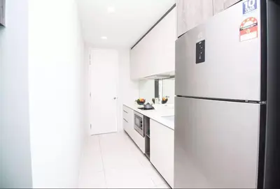 a white kitchen with a refrigerator and a sink at The Robertson KL in Kuala Lumpur