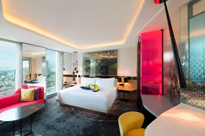 a hotel room with a white bed and a red couch at W Kuala Lumpur in Kuala Lumpur