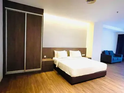 a bedroom with a bed and a sliding glass door at Imperial Regency Suites & Petaling Jaya in Kuala Lumpur