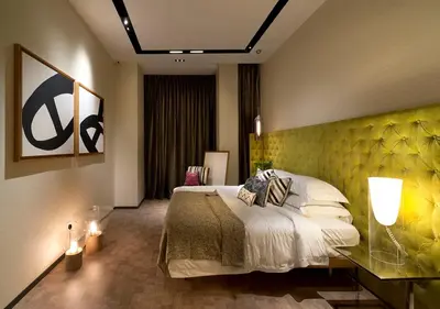 a bedroom with a bed with a yellow wall at Expressionz Suites By iHost Global in Kuala Lumpur