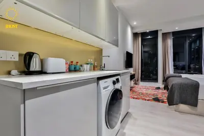 a kitchen with a washing machine under a counter at Expressionz Suites By iHost Global in Kuala Lumpur