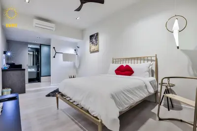 a bedroom with a large white bed with red pillows at Expressionz Suites By iHost Global in Kuala Lumpur