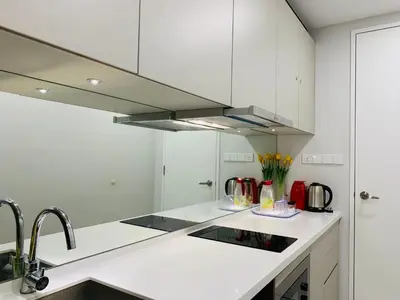 a kitchen with white cabinets and a sink at Robertson Suites Kuala Lumpur in Kuala Lumpur