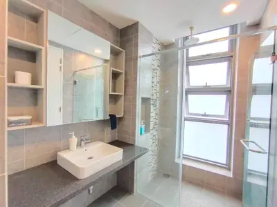 a bathroom with a sink and a glass shower at Robertson Suites Kuala Lumpur in Kuala Lumpur