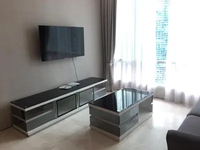 a living room with a tv and a glass coffee table at Soho Suites KL City Centre in Kuala Lumpur