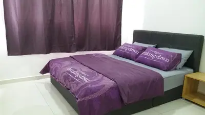a bed with purple sheets and pillows in a room at Adna Homestay Wangsa Maju in Kuala Lumpur