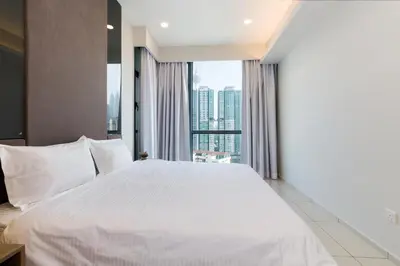 a bedroom with a large white bed with a large window at Robertson Suites by Airhost in Kuala Lumpur