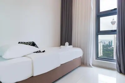 a white bed in a room with a window at Robertson Suites by Airhost in Kuala Lumpur