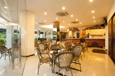 a dining room with tables and chairs in a restaurant at LEO Express Hotel in Kuala Lumpur