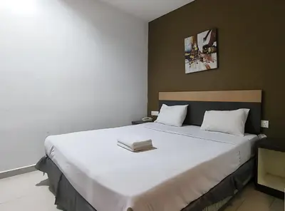 a bedroom with a large white bed with a book on it at LEO Express Hotel in Kuala Lumpur