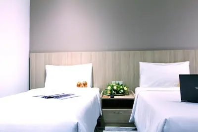 a room with two beds and a laptop on a table at Pacific Express Hotel Chinatown in Kuala Lumpur