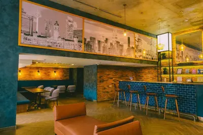 a restaurant with a bar with chairs and tables at Travelodge Kuala Lumpur City Centre in Kuala Lumpur