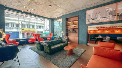 a living room with a couch and red chairs at Travelodge Kuala Lumpur City Centre in Kuala Lumpur