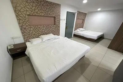 a hotel room with two beds and a mirror at Poorna Hotel at Jalan Ipoh Sentul Kuala Lumpur in Kuala Lumpur