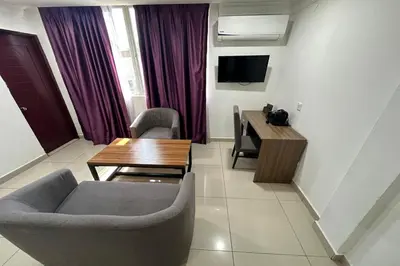a living room with a table and chairs and a television at Poorna Hotel at Jalan Ipoh Sentul Kuala Lumpur in Kuala Lumpur