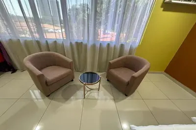 two chairs and a table in front of a window at Poorna Hotel at Jalan Ipoh Sentul Kuala Lumpur in Kuala Lumpur
