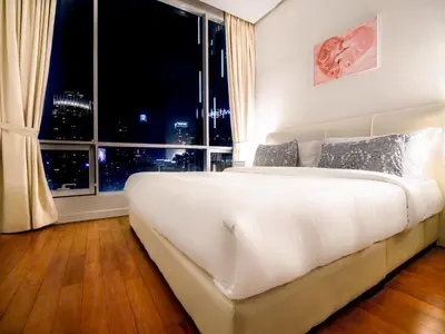 a large white bed in a room with a large window at Soho Suites KLCC by Alucard\uff08\u5409\u9686\u5761KLCC Alucard Soho\u5957\u623f\u516c\u5bd3\uff09 in Kuala Lumpur