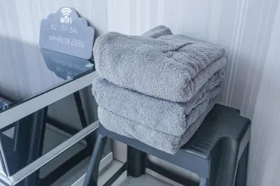 a pile of towels sitting on top of a stool at Soho Suites KLCC by Alucard\uff08\u5409\u9686\u5761KLCC Alucard Soho\u5957\u623f\u516c\u5bd3\uff09 in Kuala Lumpur