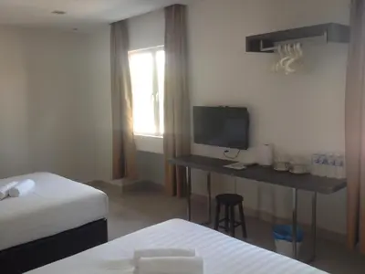 a room with two beds and a desk with a television at Festival Boutique Hotel @ Kampung Pandan in Kuala Lumpur
