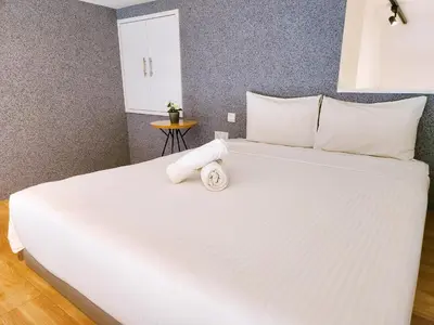 a large white bed with a towel on it at The Establishment Bangsar in Kuala Lumpur