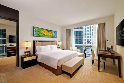 a large hotel room with a bed and a desk and a desk at Pavilion Hotel Kuala Lumpur Managed by Banyan Tree in Kuala Lumpur