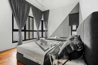 a bedroom with a bed with white sheets and windows at The Mews KLCC by Plush in Kuala Lumpur
