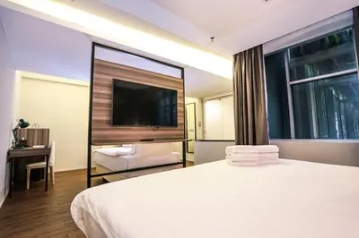 a hotel room with a large bed and a television at Days Hotel & Suites by Wyndham KL - Chan Sow Lin MRT or LRT in Kuala Lumpur