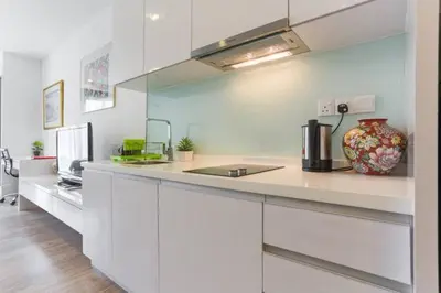a kitchen with white cabinets and a vase on a counter at Perfect Location#2 @Heart of KL City Centre next to Metro MRT in Kuala Lumpur