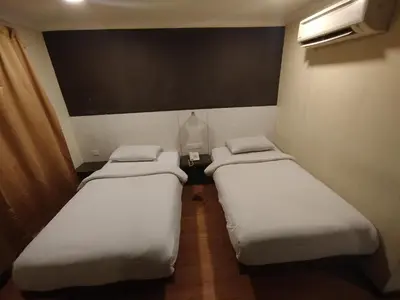a row of three beds in a room at Hotel De Grand Orchard in Kuala Lumpur